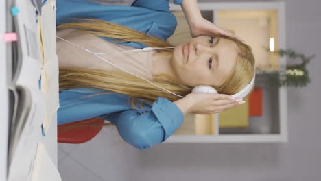 Vertical-video-of-Happy-Female-student-listening-to-music.